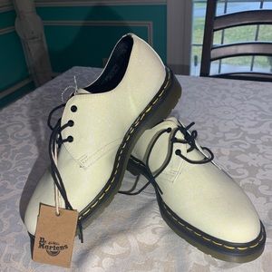 Dr. Martens Men’s white glitter finish shoes.